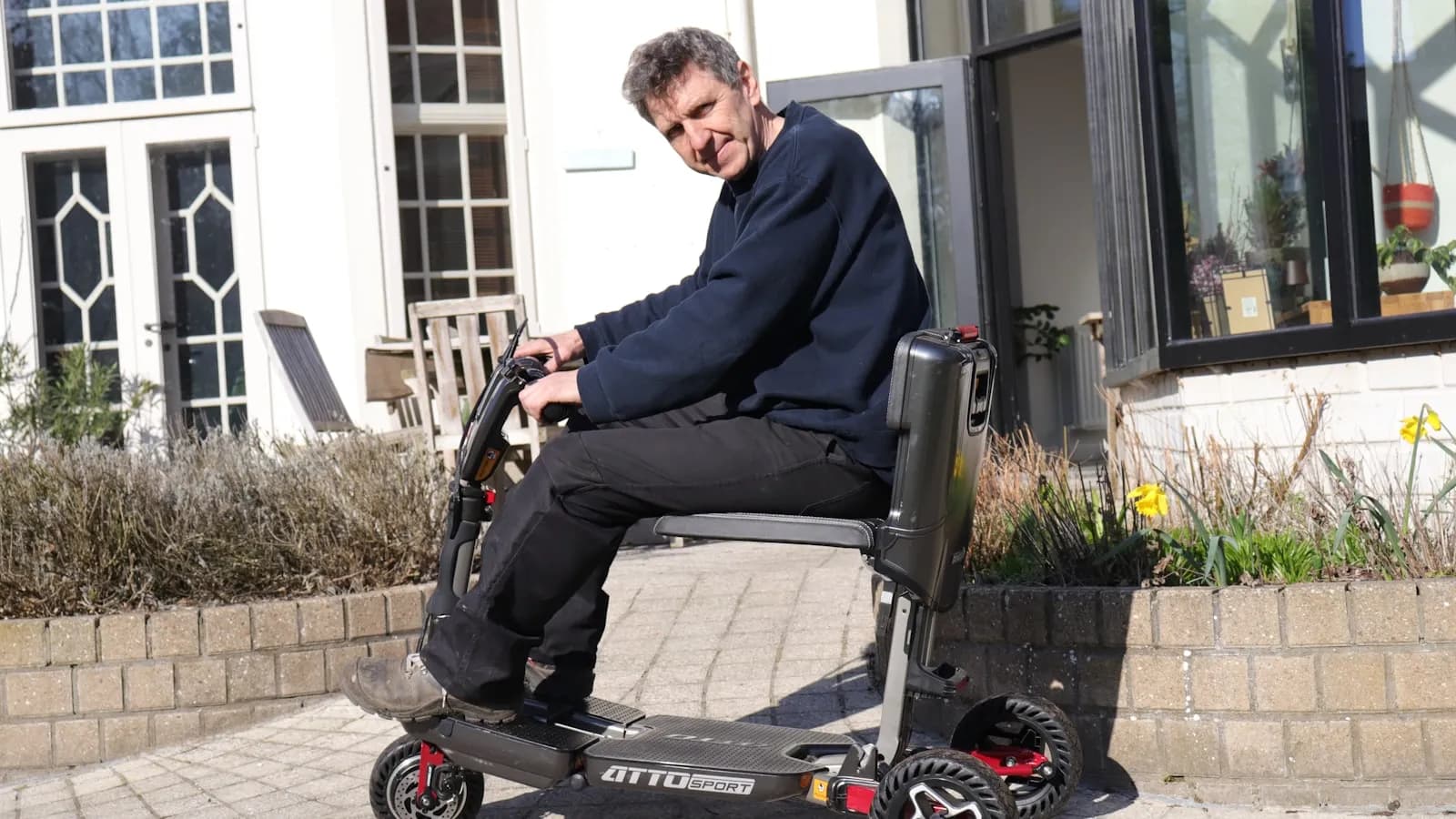 Scootmobiel bij een woning — kopen of huren afweging voor senioren