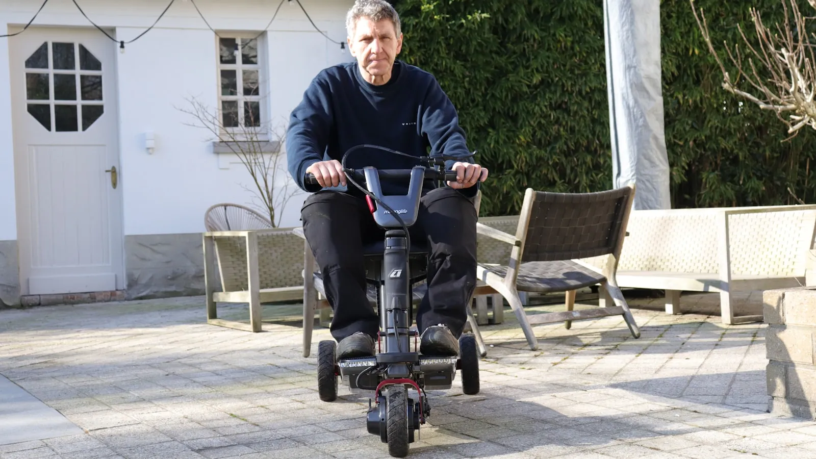 Senior op scootmobiel in een rustige straat — eerste rit veiligheid en oefenen