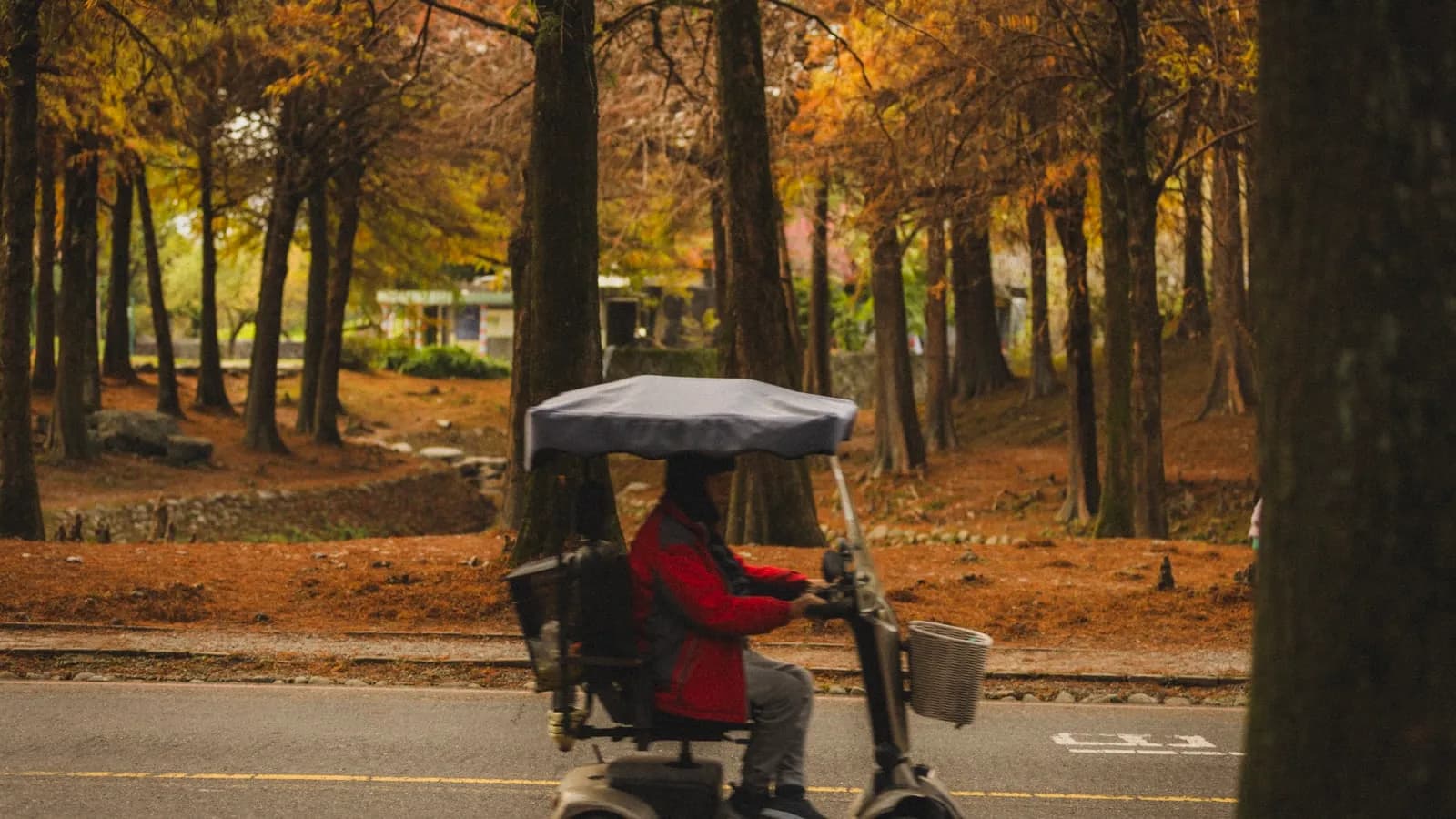 Senior rijdt buiten op een scootmobiel — accu, bereik en laadtijd